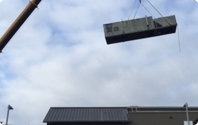 Commercial crane being used to move rooftop HVAC units onto building in Kent, Washington.