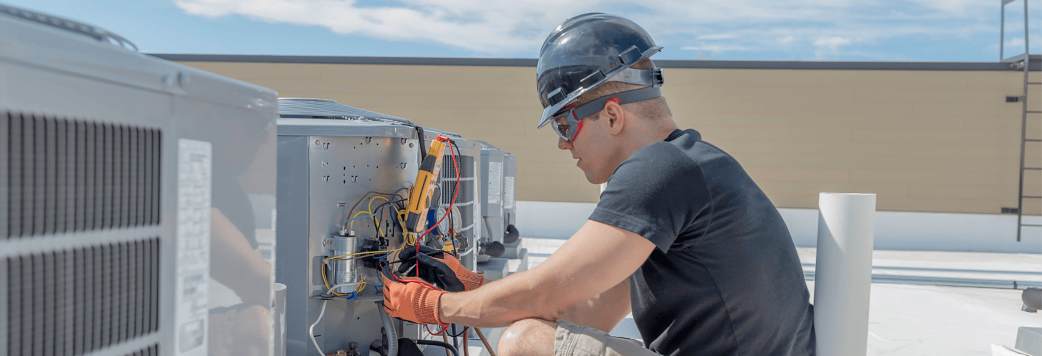 Performance Mechanical Group technician performing maintenance on commercial rooftop units in Seattle, WA.